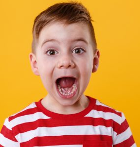Close up portrait of a little boy screaming out loud