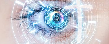 Blue eye looking forward with circled and numbers and letters covering it to give a digital effect